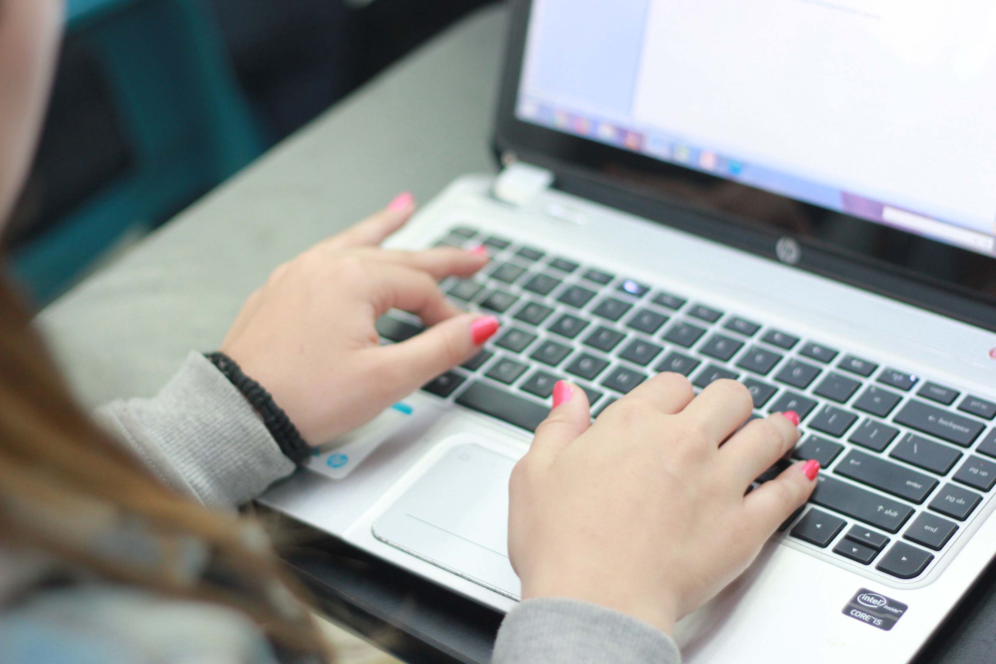 Hände beim Tippen auf einer Laptop-Tastatur
